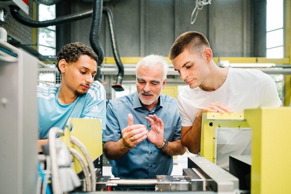 Zwei Studenten mit dem Professor im Labor.