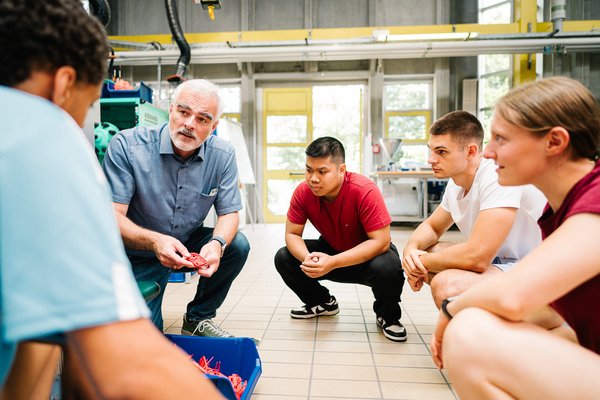 Studierende und Professor in der Maschinenhalle.